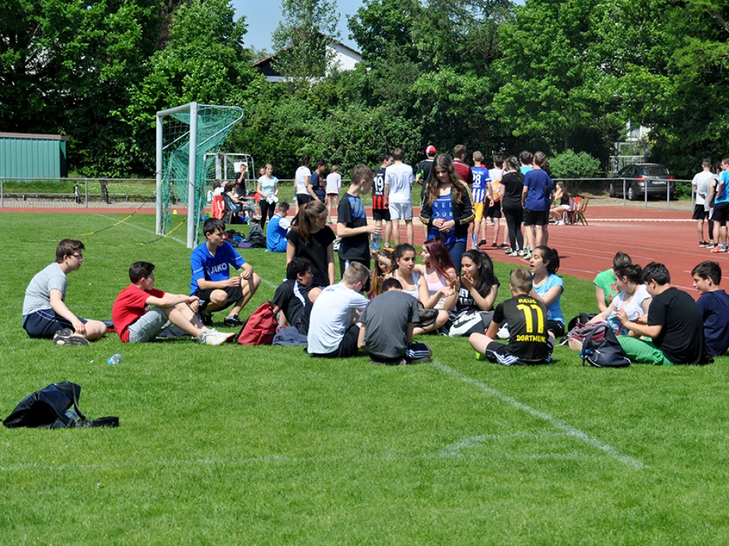 Gruppen sitzen auf dem Rasen und ruhen sich aus.